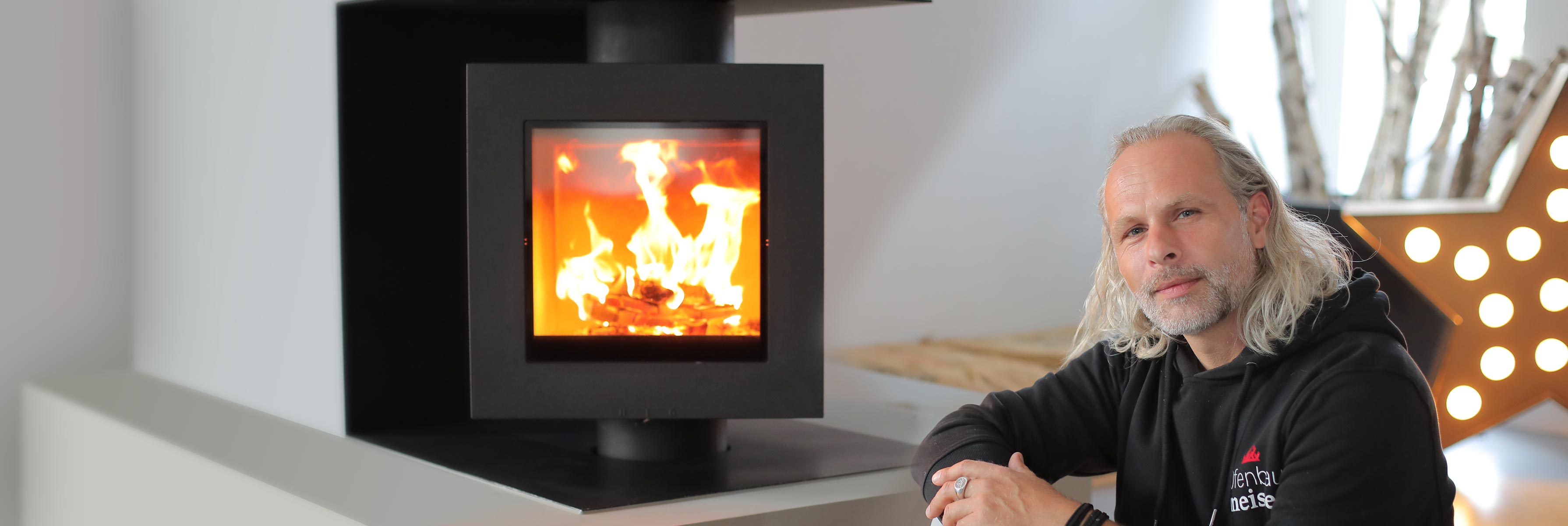 Ofenbauer Rosenheim - Hendrik Kraus neben Kaminofen