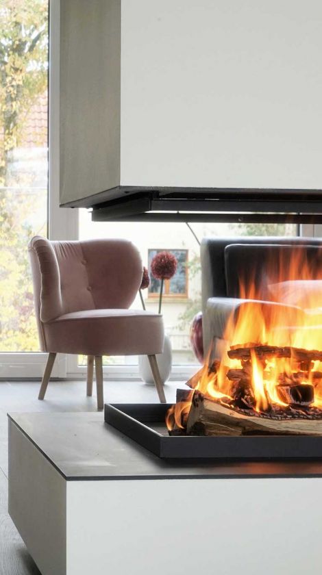 Ofenbau Miesbach Feuer im Kamin und gemütlicher Hocker daneben
